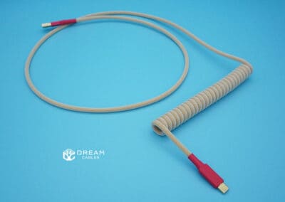 Coiled mechanical keyboard cable in light yellow with red accents and a 6-inch coil
